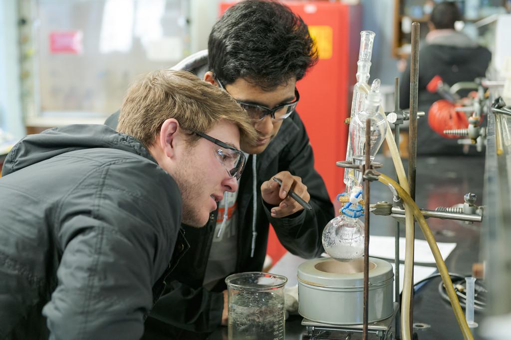 Two students work on a synthesis project during an organic chemistry lab.